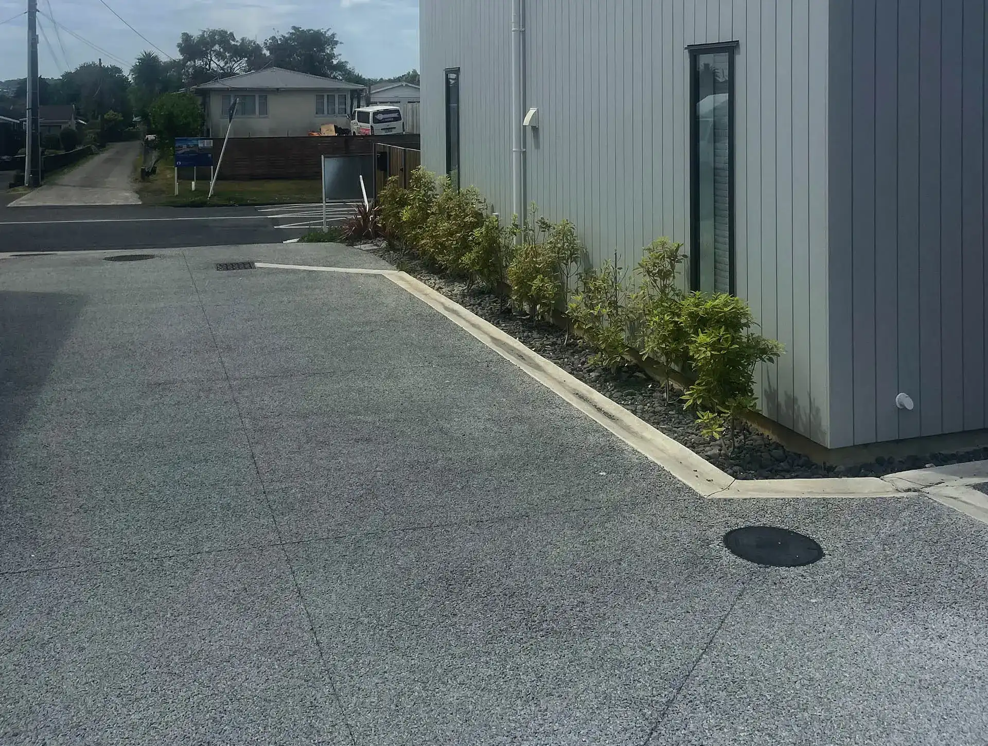 Large permeable concrete hardstand poured beside a commercial building