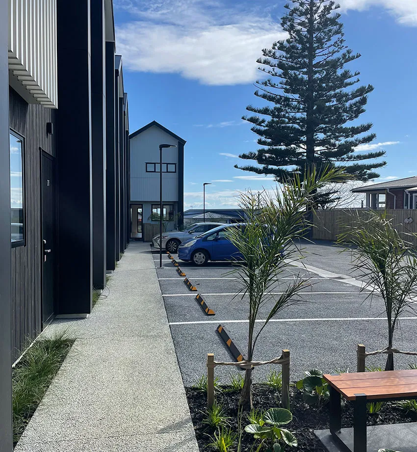 Newly paved permeable concrete driveway in front of a brick home.