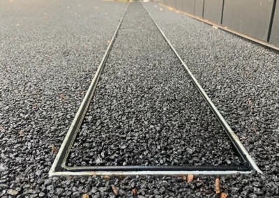 Close-up of permeable concrete surface with linear drainage system.